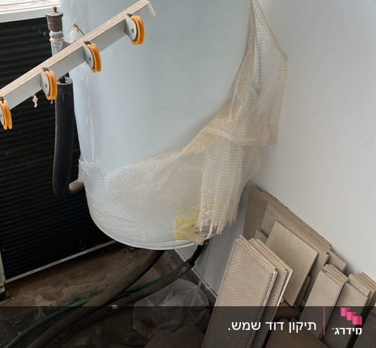 דוד שמש מותקן על קיר עם צינורות מחוברים